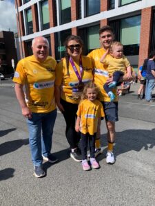 Peter and his family pose for camera wearing yellow t-shirts with the Bluescope logo on the front.