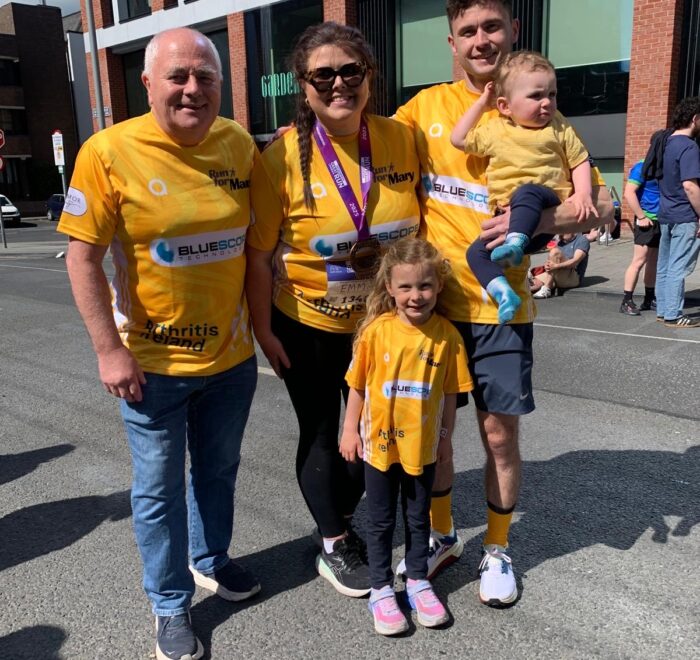 Peter and his family pose for camera wearing yellow t-shirts with the Bluescope logo on the front.