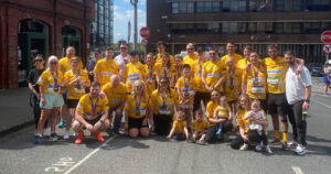 Group of people wearing yellow t-shirts for Arthritis Ireland with Bluescope logo on front.