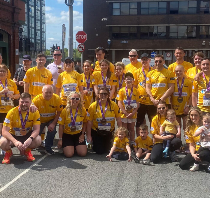 Group of people wearing yellow t-shirts for Arthritis Ireland with Bluescope logo on front.